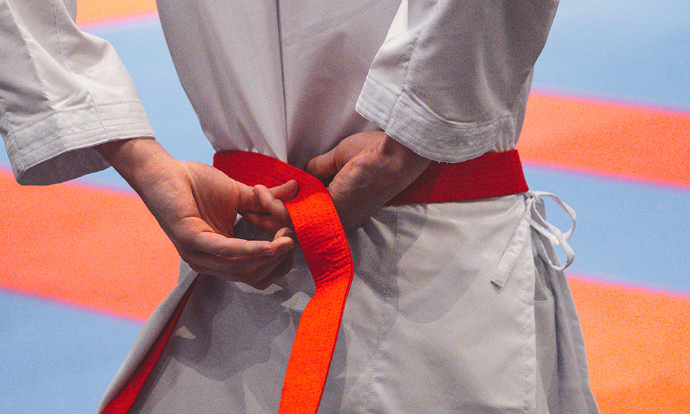 man tying belt wearing gi