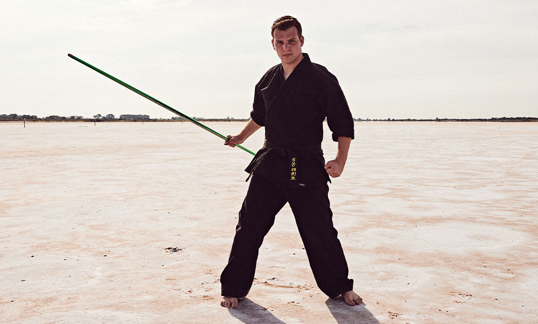 martial artist with bo staff outside