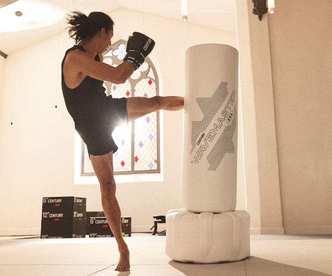 martial artist kicking training bag